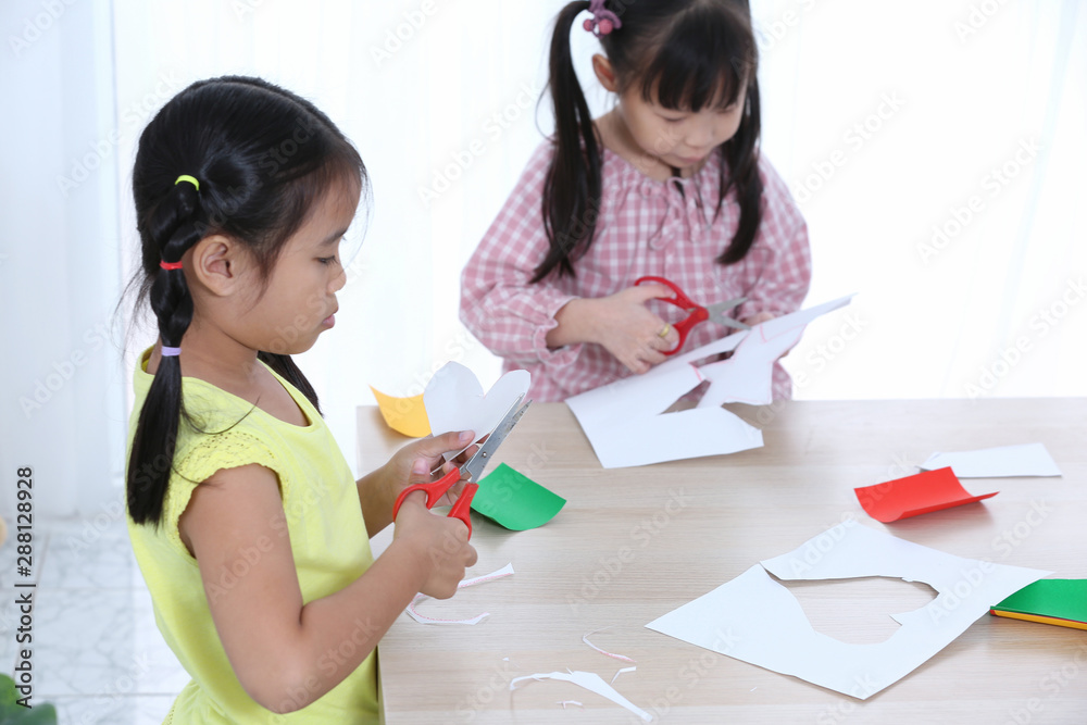 Home school education two girl cutting colored paper to do homework cut by scissors. Home school education two girl cutting colored paper to do homework cut by scissors.