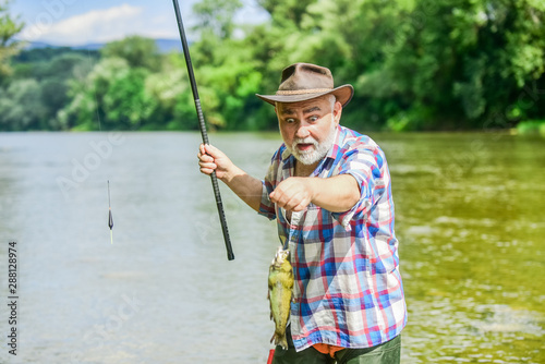Fisherman with fishing rod. Activity and hobby. Fishing freshwater lake pond river. It is not sport, it is obsession. Senior bearded man catching fish. Mature man fishing. Retired bearded fisherman