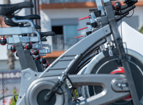 Photo detail of many stationary bicycles in a gym.