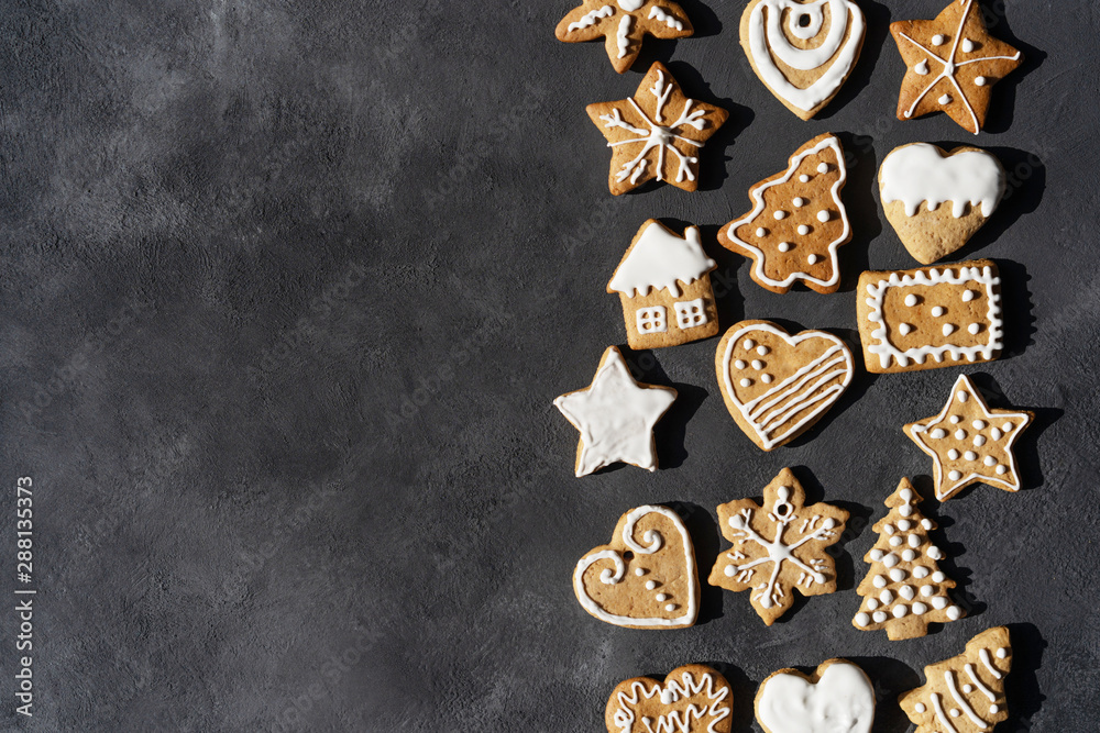 Christmas background, frame on a dark background with fragrant glazed varied gingerbreads in the different shapes. Family handmade. Copy space for text. Festive concept. Christmas background, frame on a dark background with fragrant glazed varied gingerbreads in the different shapes. Family handmade. Copy space for text. Festive concept.