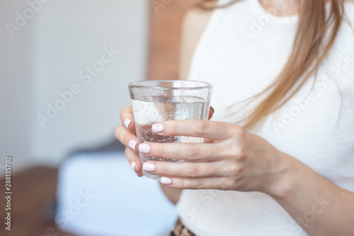 Female hands holding a clear glass of water.A glass of clean mineral water in hands, healthy drink.