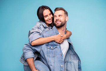 Portrait of charming couple hugging looking wearing denim jeans isolated over blue background