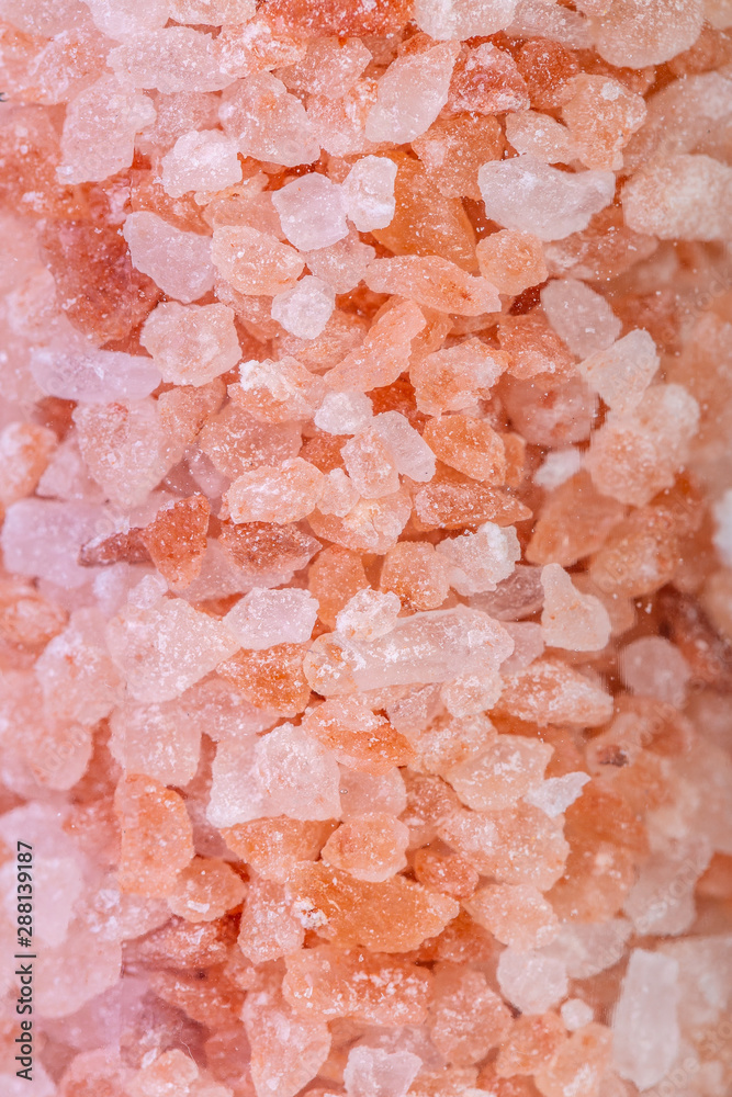 Himalayan salt crystals in a glass grinder on white background Himalayan salt crystals in a glass grinder on white background