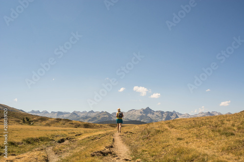 Woman hiking through a high mountain valley
