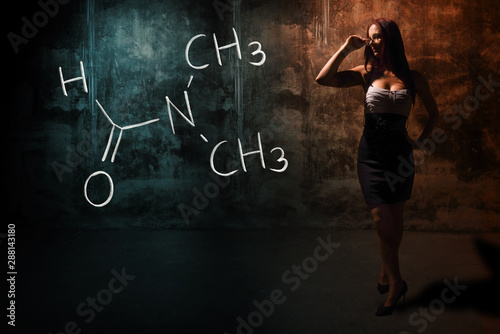 Sexy girl or secretary or female student presenting handdrawn chemical formula of dimethylformamide photo