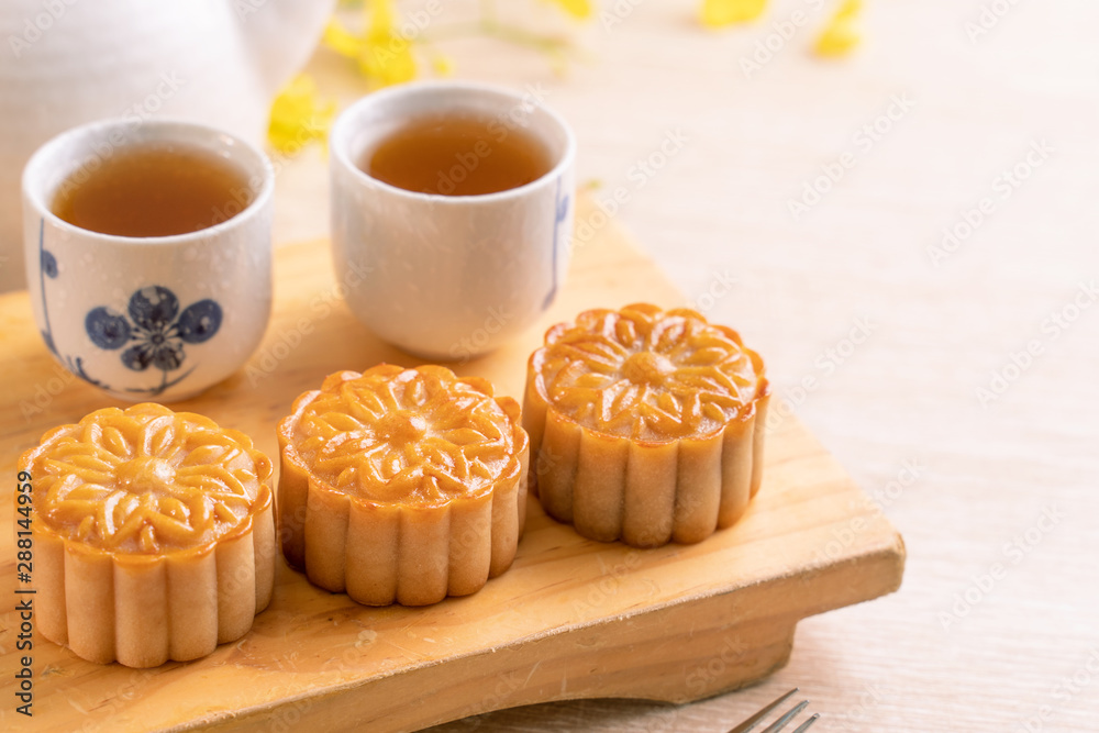 Mid-Autumn Festival holiday concept design of moon cake,mooncakes,tea set on bright wooden table and serving plate with copy space, close up.