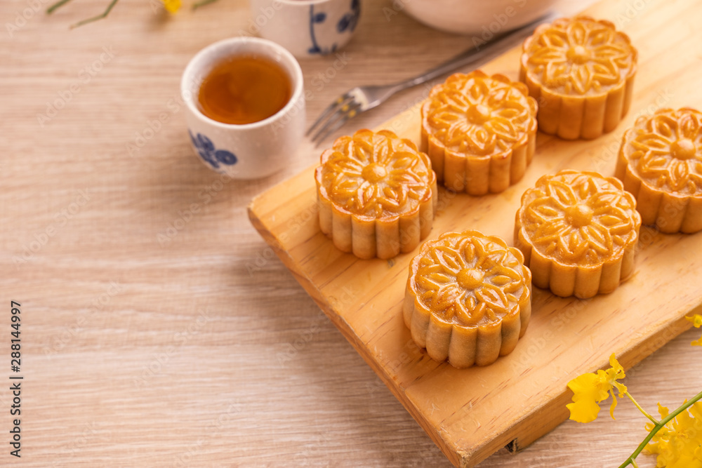 Mid-Autumn Festival holiday concept design of moon cake,mooncakes,tea set on bright wooden table and serving plate with copy space, close up. Mid-Autumn Festival holiday concept design of moon cake,mooncakes,tea set on bright wooden table and serving plate with copy space, close up.