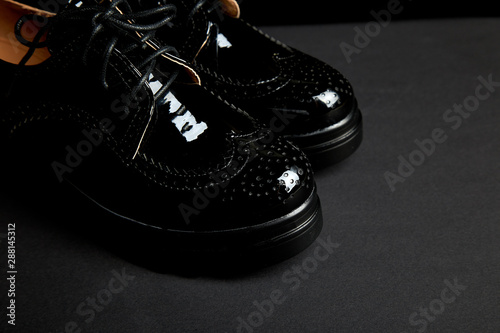 Woman female black oxford platform shoes on black background.