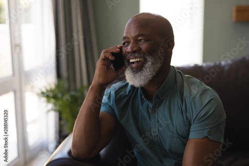 Canvastavla Senior man talking on mobile phone in living room
