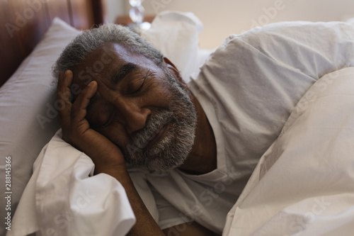 Senior man sleeping in bedroom at home