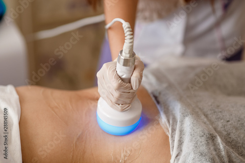 Hardware cosmetology. Body care. Spa treatment. Ultrasound cavitation body contouring treatment. Woman getting anti-cellulite and anti-fat therapy in beauty salon.