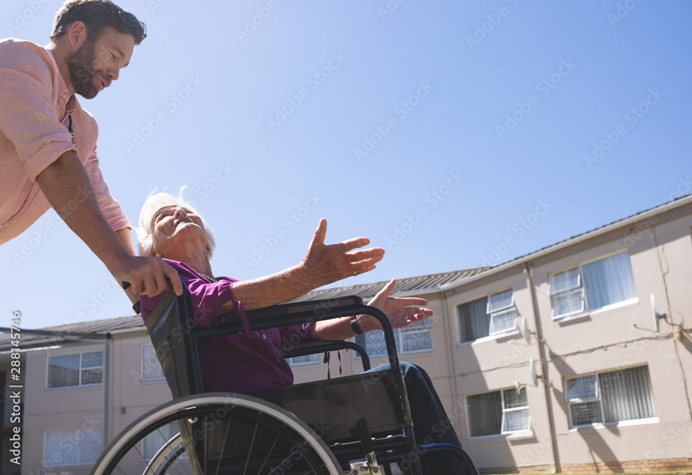 Obraz premium Male doctor talking with disabled senior patient women in wheelchair