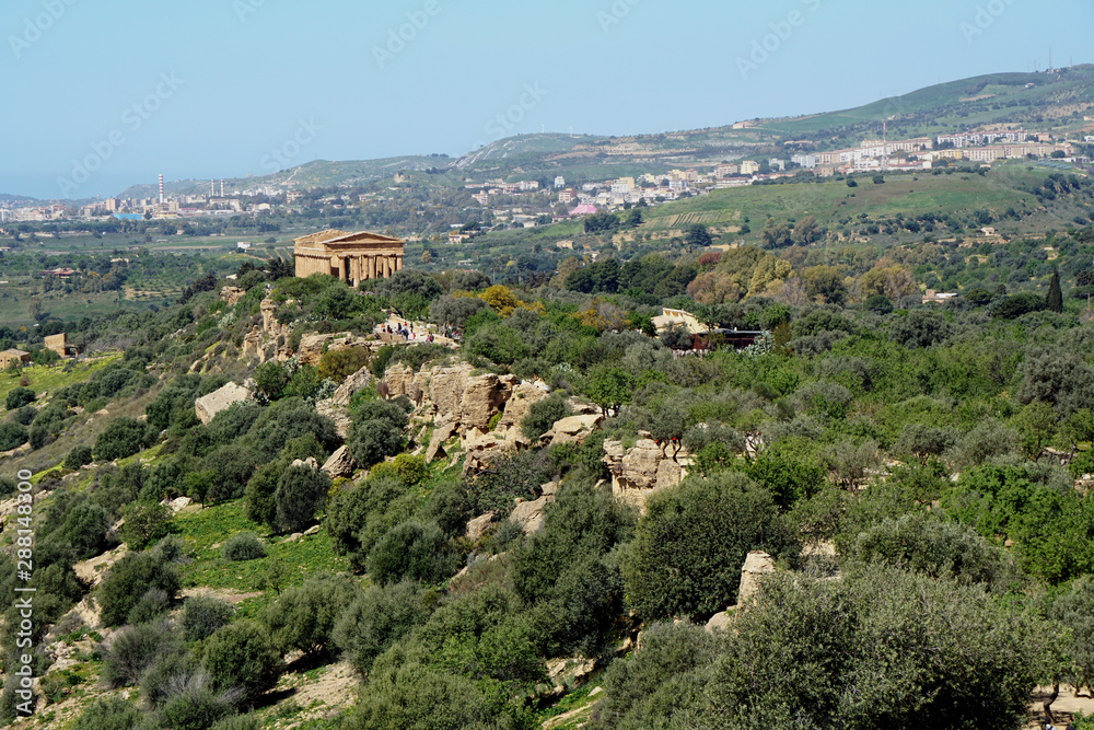 View to the temple of Concordia in the valley of temples with Agrigento in the background   