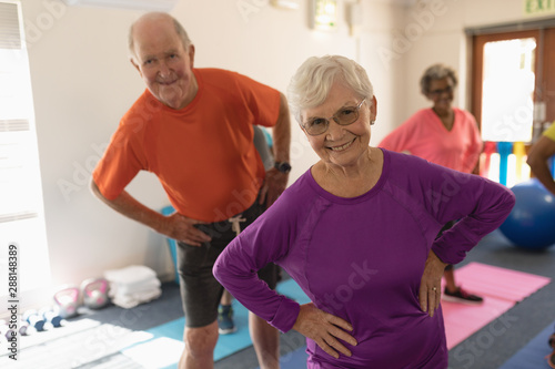Front view of senior couple exercising in fitness studio 