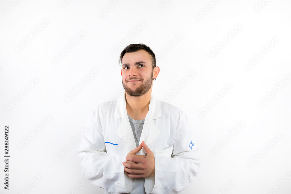 Smiling and thoughtful young male doctor with beard looking up isolated on white background Smiling and thoughtful young male doctor with beard looking up isolated on white background