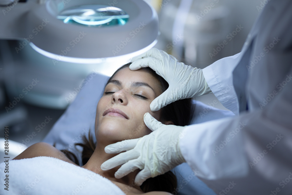 Surgeon examining patient during plastic surgery Surgeon examining patient during plastic surgery