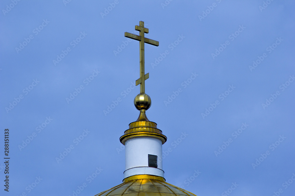 .The upper part of the gilded dome of the temple with a cross.