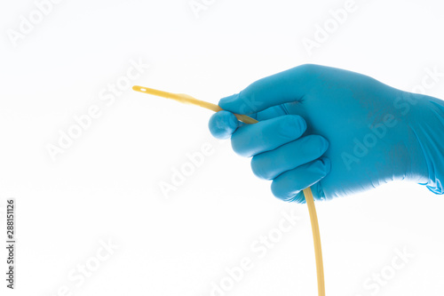 urethral catheter hold on blue glove hand on white background photo