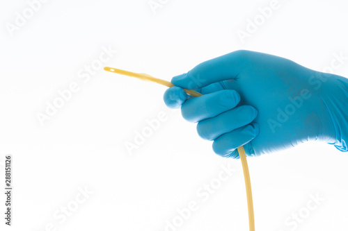 urethral catheter hold on blue glove hand on white background