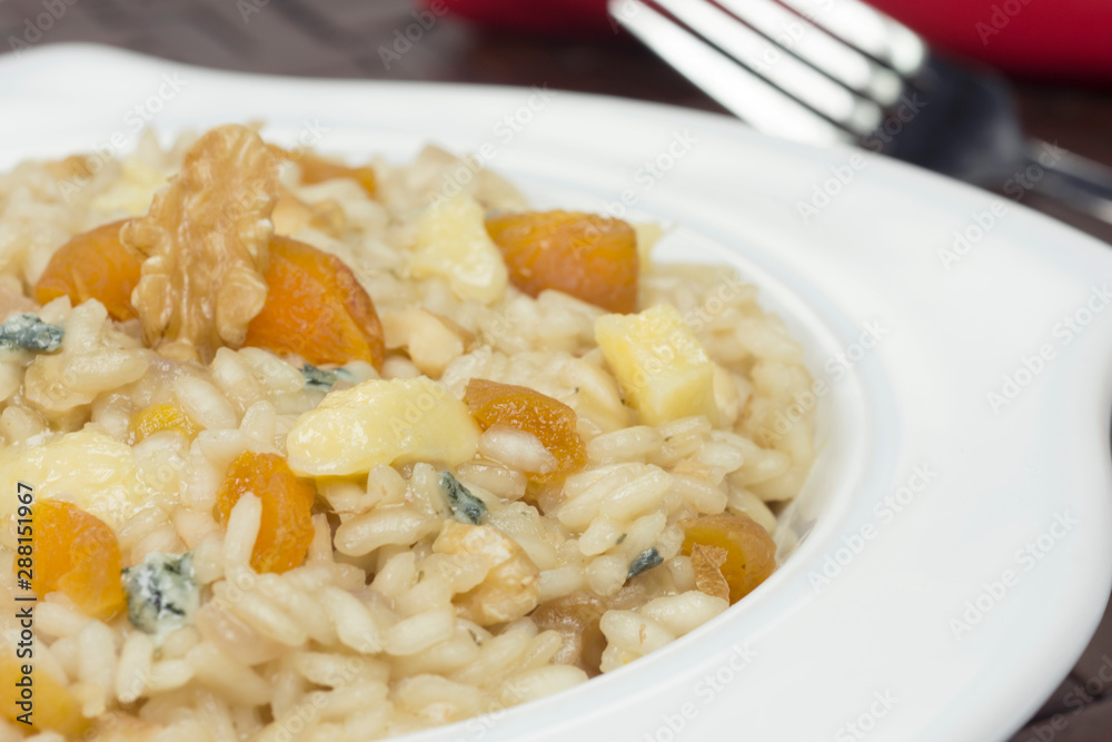 Gorgonzola cheese risotto with damascus and walnuts close Gorgonzola cheese risotto with damascus and walnuts close