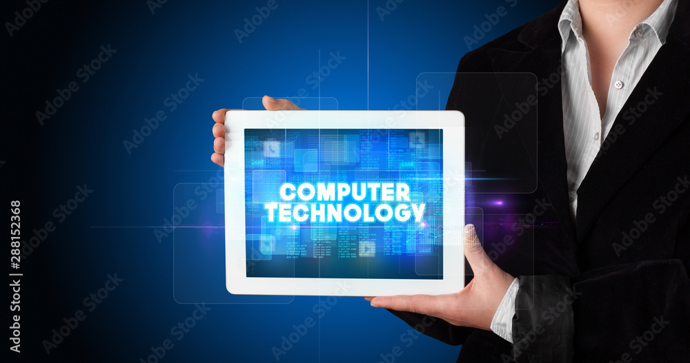 Young business person working on tablet and shows the inscription: COMPUTER TECHNOLOGY