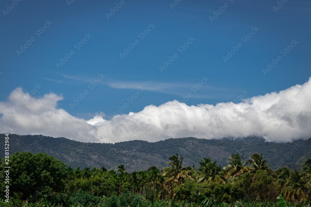 Fototapeta premium Mountains Velliangiri view with blue sky and green forest
