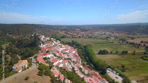 Aerial, drone shot, panning around the Aljezur village, on hill, near the castle, on a sunny day, in Vicentine coast national park, in Algarve, Portugal photo