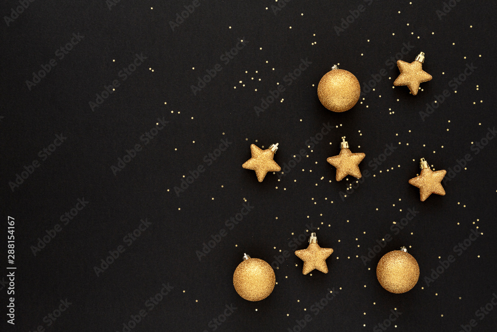 Fototapeta premium Beautiful Christmas golden decoration on black background. Beautiful Glowing overlay for holiday greeting card. Flat lay composition. Copy Space.