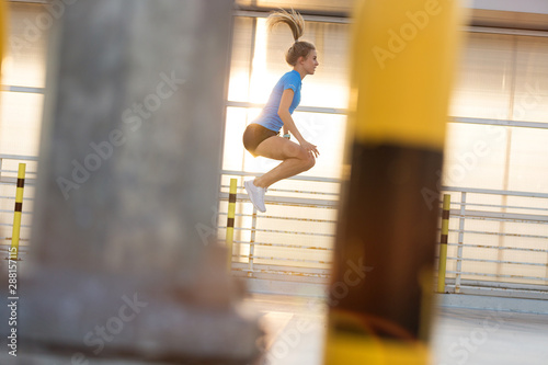 Young woman doing fitness exercise in urban area