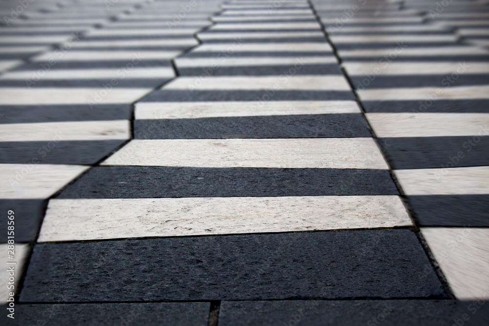 Black and white zigzag zebra tile road crosswalk background with bokeh