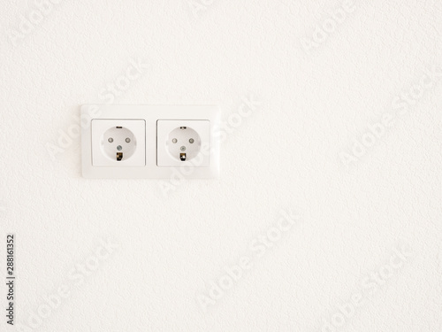 Modern white double socket on the wall. Household electrical equipment.