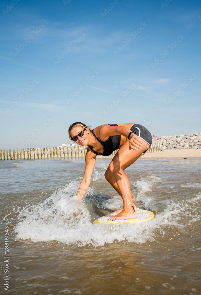 Fototapeta premium young athletic surfer having fun on the beach