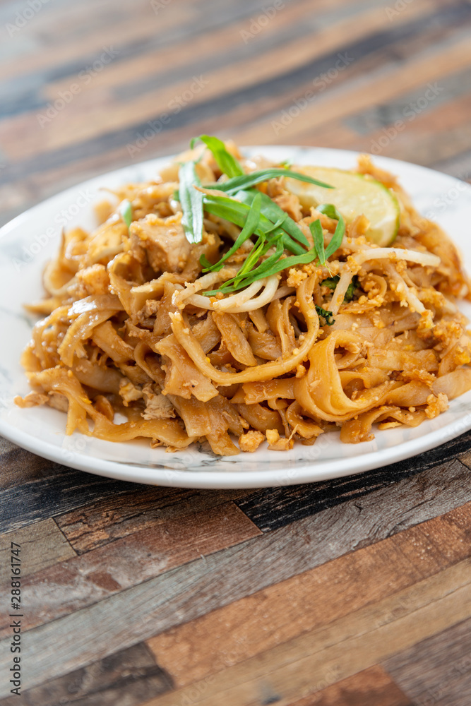 Pad Thai, vegan recipe made with rice noodles, vegetables and peanuts cooked on wok.