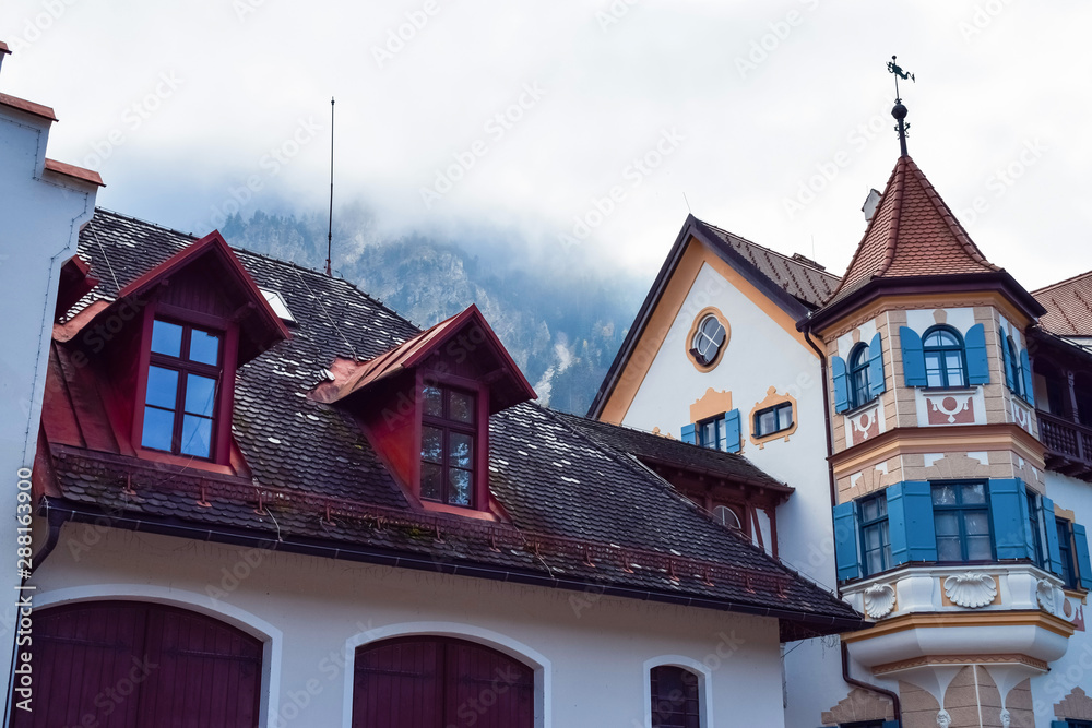 Red roof of an old building with fog in the mountains in the morning