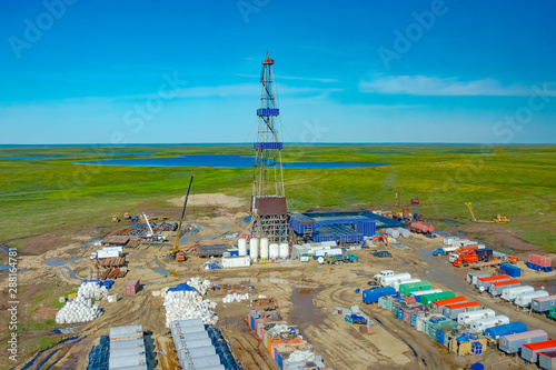Drilling rig and equipment at an oil field in the northern tundra. Top view from a helicopter. Green summer tundra with lakes beyond the Arctic Circle. photo