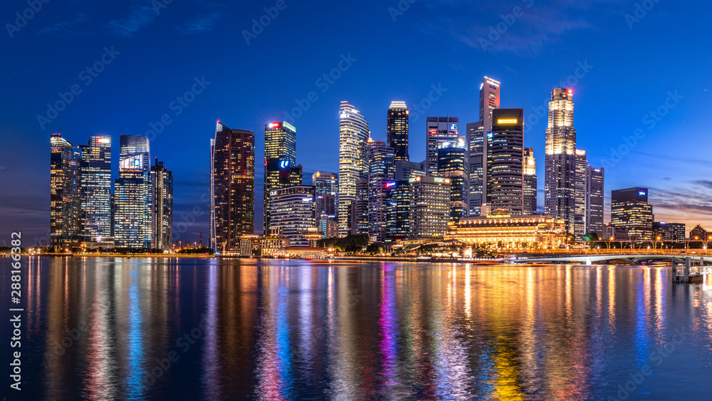 Obraz premium Marina bay,Singapore - 2017 September 21 : Singapore business building skyline at dawn with reflexion on waterbay in twilight time.