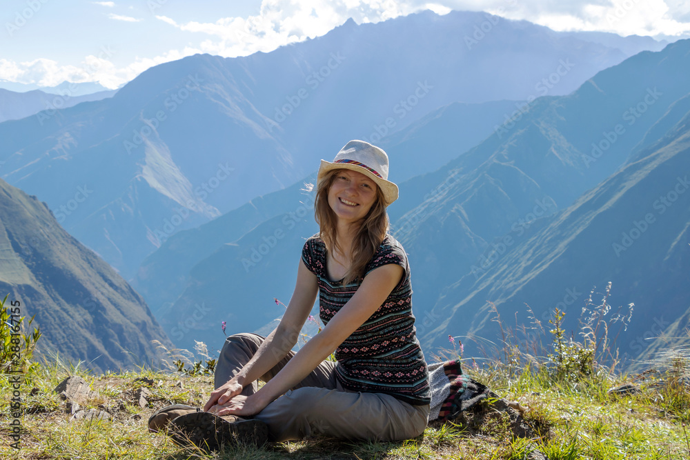 Young free woman travel alone in Andes mountains in Peru. Landscape with solo female tourist, mountains and copy space