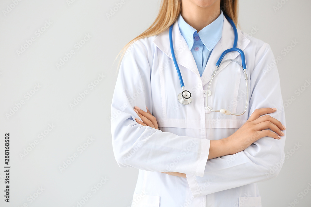 Female doctor with stethoscope on light background Female doctor with stethoscope on light background