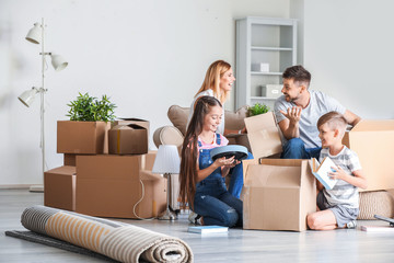 Happy family unpacking belongings in their new house