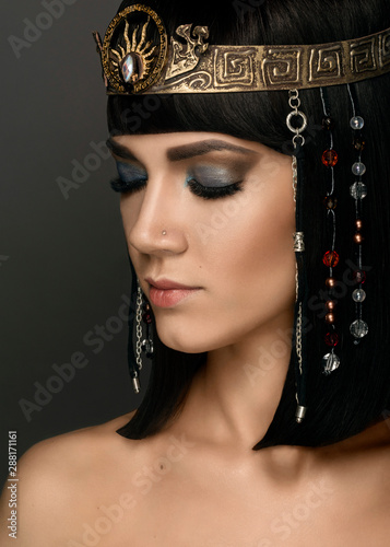 Close-up portrait of beautiful woman with bright make-up and with gold jewelery.Beautiful Girl's Face Close-up. Haircut. Hairstyle. Glamorous. High fashion look. Cleopatra 