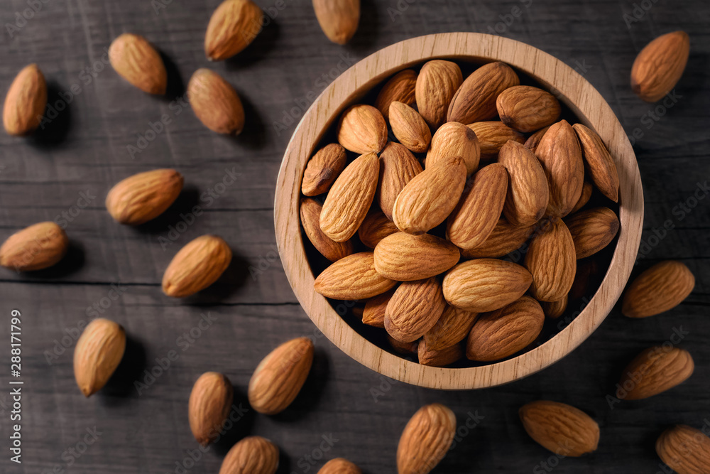almonds in bowl wood on dark table background almonds in bowl wood on dark table background