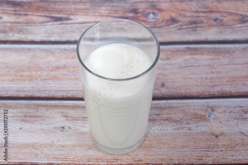 glass of milk on wooden background from above