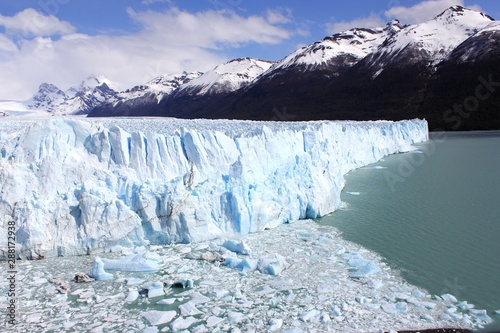 Wall of ice in the Perito Moreno glacier, in Argentina, Patagonia. In the background dark mountains with snow in the peakst