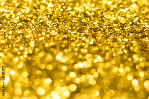 Gold glitter texture. Festive sparkling sequins background. Wpaper for Valentine, New Year or Christmas Holidays.