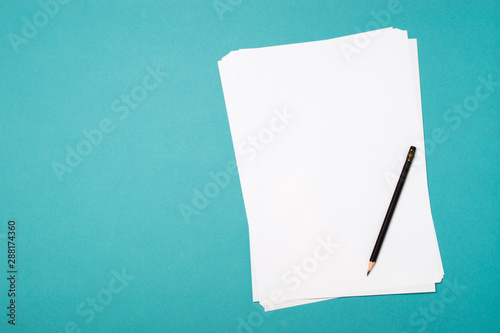 Blank paper sheet and pencil for mock up on a blue background