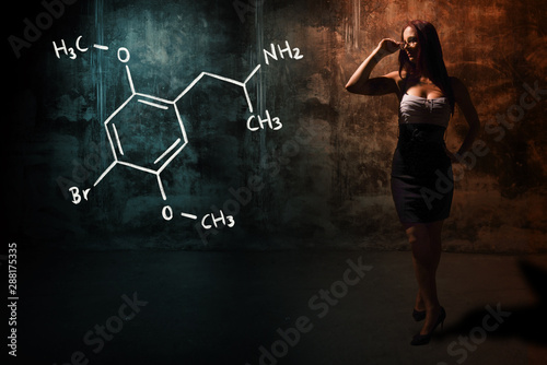 Sexy girl or secretary or female student presenting handdrawn chemical formula of Dimethoxybromoamphetamine dob