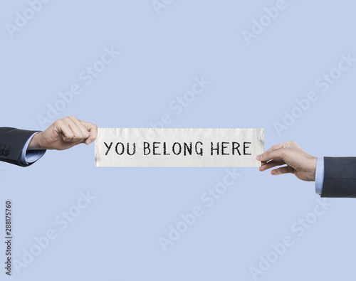 Fotografie you belong here   businessman holding message.