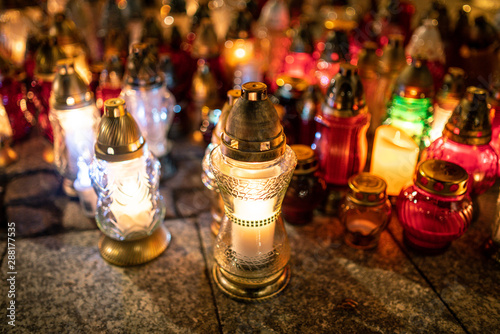 Jars with burning candles on stone surface at night