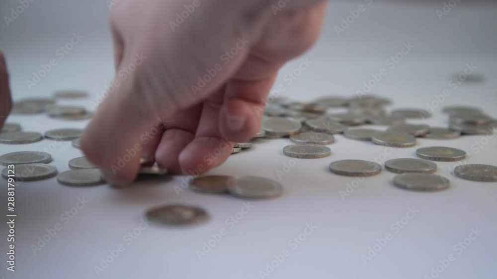 Picking up some 2 Euro coins against white background in 4K Picking up some 2 Euro coins against white background in 4K
