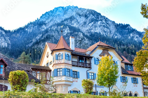 Fairytale house with a balcony on a background of a high mountain in autumn in Alps